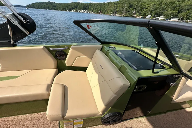 Slide: The Image of 2023 MasterCraft NXT 22 boat interior with beige seating on a lake. - 21