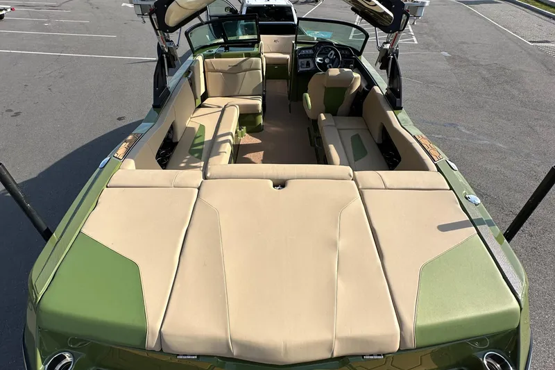 Slide: The Image of 2023 MasterCraft NXT 22 boat interior with beige and green seating. - 22