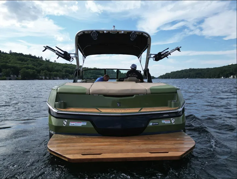 Slide: The Image of 2023 MasterCraft NXT 22 boat on a lake with two people onboard. - 24