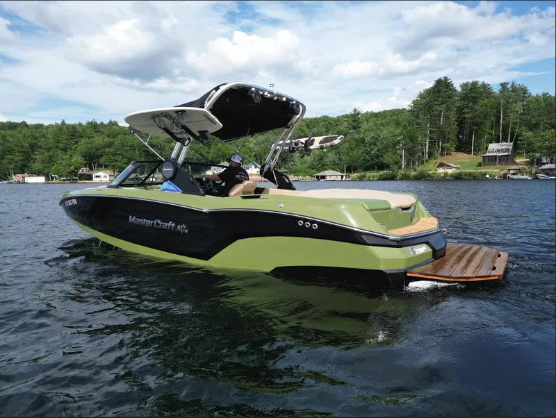 Slide: The Image of 2023 MasterCraft NXT 22 boat on a lake with scenic background. - 25