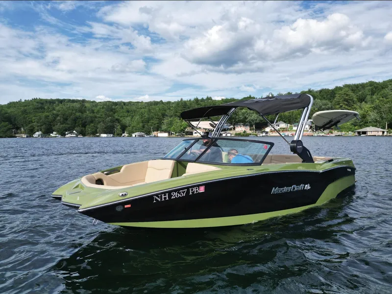 Slide: The Image of 2023 MasterCraft NXT 22 boat on a lake with scenic background. - 27