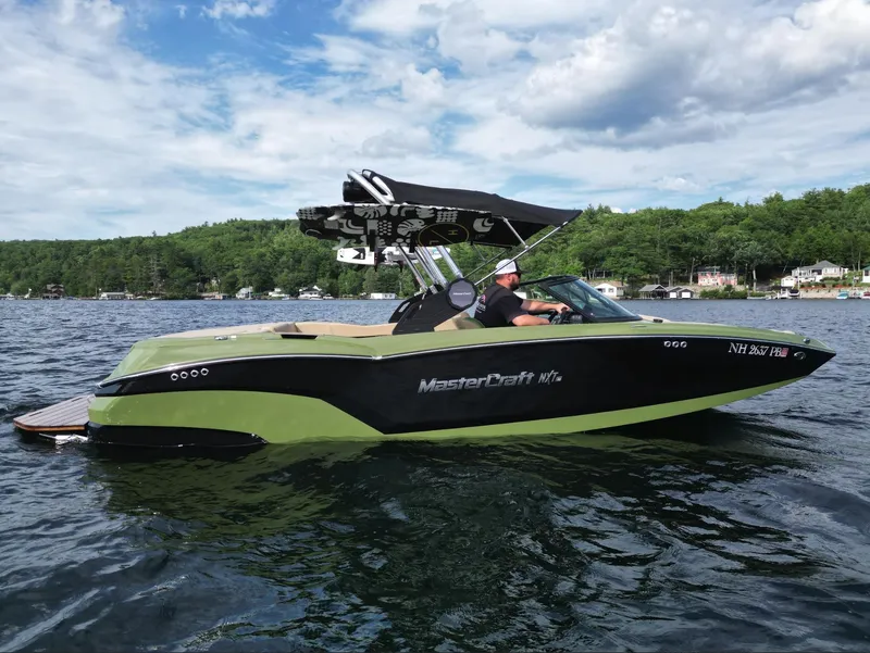 Slide: The Image of 2023 MasterCraft NXT 22 boat on a lake with scenic background. - 29
