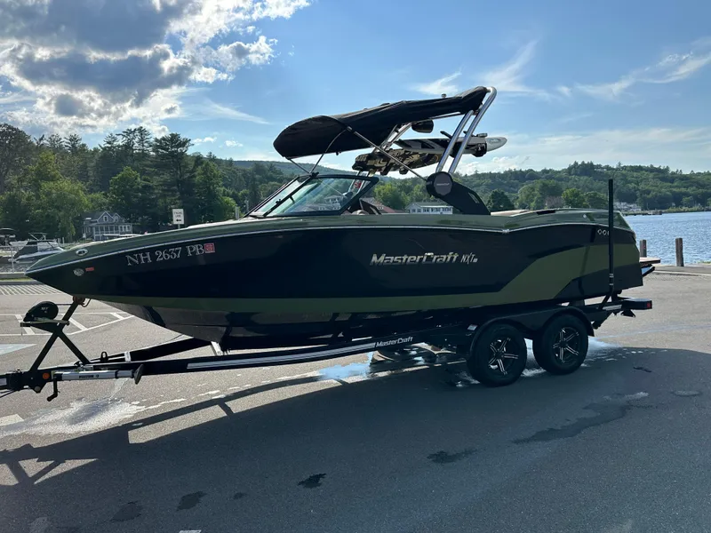 Slide: The Image of 2023 MasterCraft NXT 22 boat on trailer by a lake. - 3