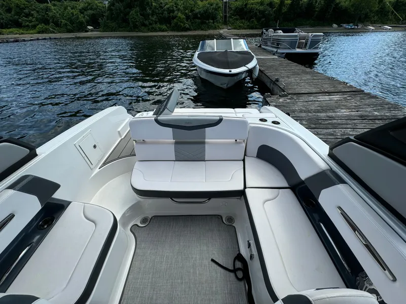 Slide: The Image of 2019 Chaparral 257 SSX boat interior with seating, docked by a wooden pier. - 7