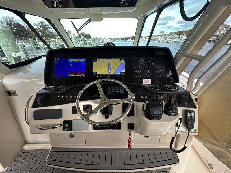Slide: The Image of 2019 Grady-White Canyon boat dashboard with navigation screens and steering wheel. - 9