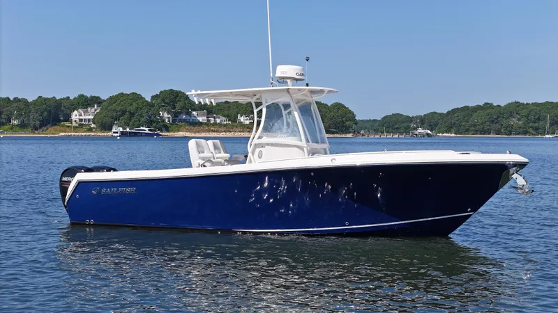 Slide: The Image of 2016 Sailfish 270 CC boat on calm water, featuring a sleek blue hull. - 1