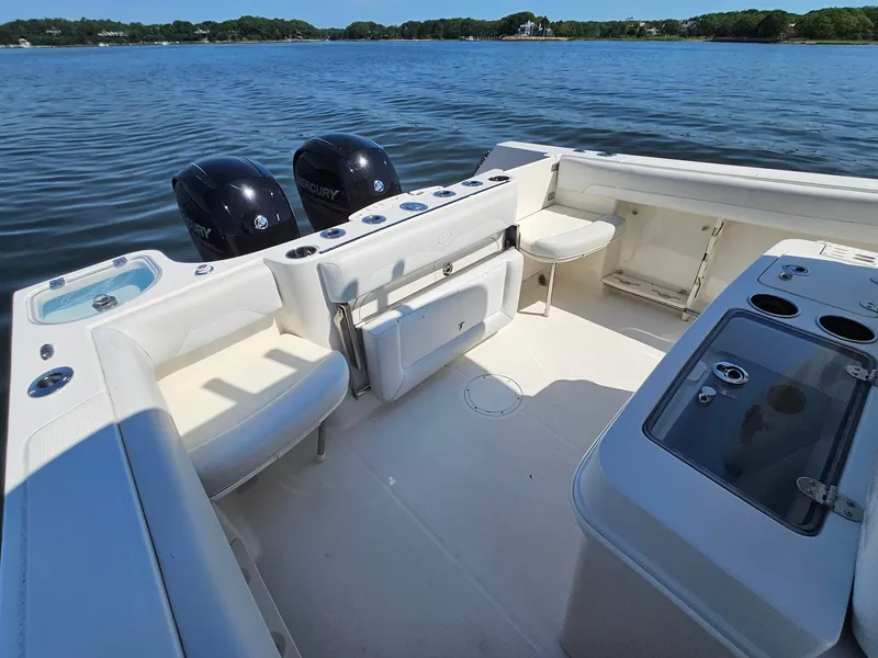 Slide: The Image of 2016 Sailfish 270 CC boat interior with dual Mercury engines on a calm lake. - 11