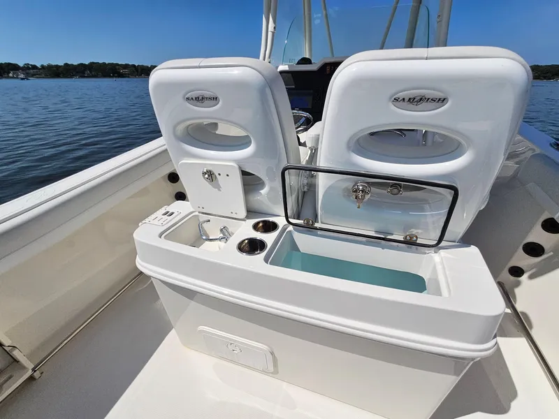 Slide: The Image of 2016 Sailfish 270 CC boat interior with seating and storage, on a calm lake. - 13