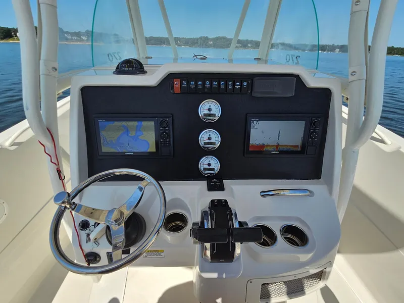 Slide: The Image of 2016 Sailfish 270 CC boat dashboard with navigation screens and steering wheel. - 16