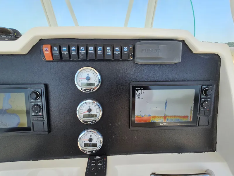 Slide: The Image of Dashboard of a 2016 Sailfish 270 CC boat with navigation instruments and Garmin displays. - 18