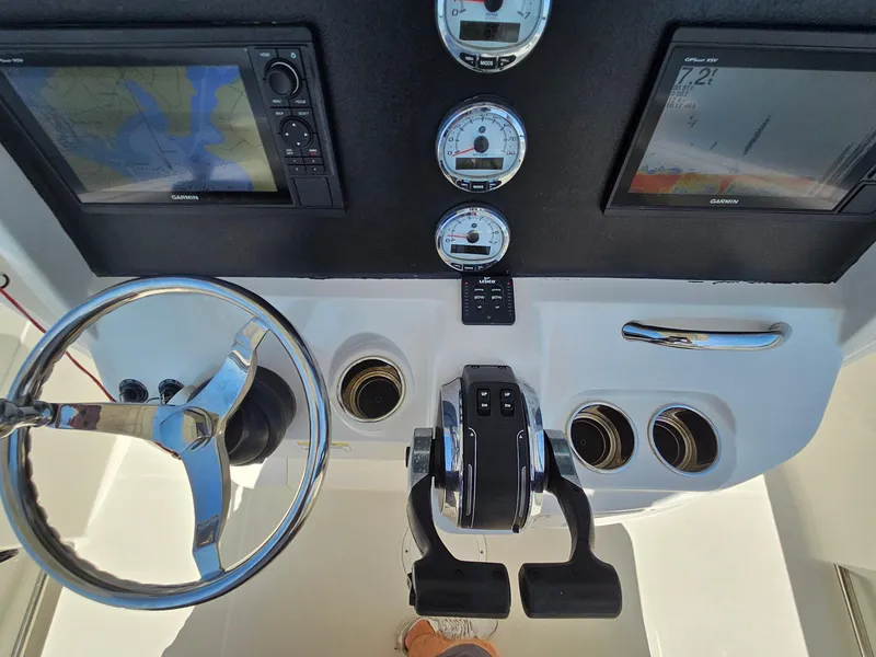 Slide: The Image of 2016 Sailfish 270 CC boat dashboard with steering wheel, dual Garmin displays, and control gauges. - 19