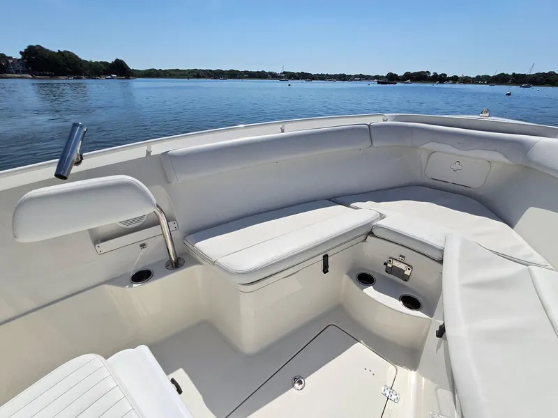 Slide: The Image of 2016 Sailfish 270 CC boat interior with white seating, on a calm lake. - 23