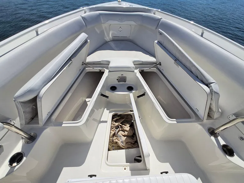 Slide: The Image of 2016 Sailfish 270 CC boat interior with open storage compartments on calm water. - 25