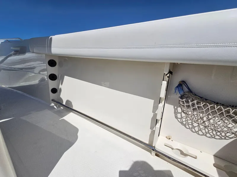 Slide: The Image of 2016 Sailfish 270 CC boat interior with storage compartment and netting. - 28