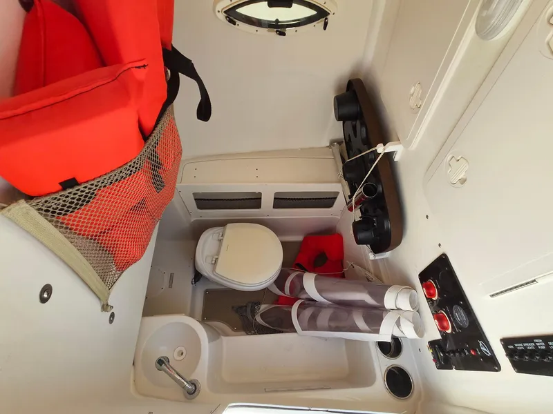 Slide: The Image of Interior of 2016 Sailfish 270 CC boat with toilet, sink, and life jackets. - 29