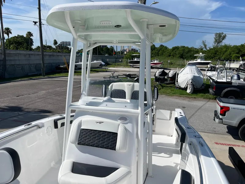Slide: The Image of 2025 Tidewater 210 CC Adventure boat with T-top and seating, docked at marina. - 7