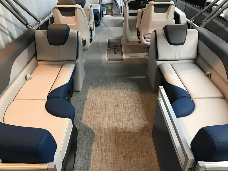 Slide: The Image of 2025 Avalon LSZ Quad Lounger boat interior with blue console and stainless steel railing. - 26