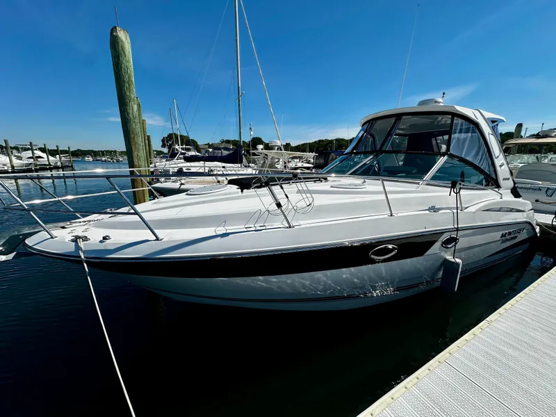 Slide: The Image of 2021 Monterey 335 Sport Yacht docked at marina under clear blue sky. - 2