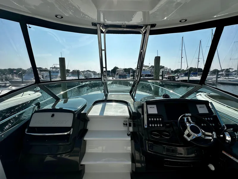 Slide: The Image of Cockpit view of 2021 Monterey 335 Sport Yacht at marina, showcasing helm and controls. - 21