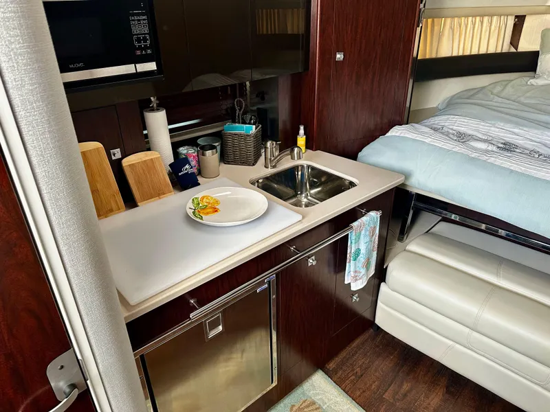 Slide: The Image of 2021 Monterey 335 Sport Yacht interior with kitchenette and bed, featuring modern amenities. - 25