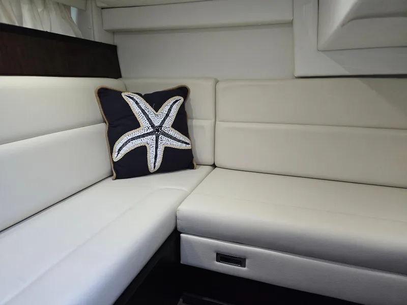 Slide: The Image of Interior of 2021 Monterey 335 Sport Yacht with starfish pillow on white seating. - 31