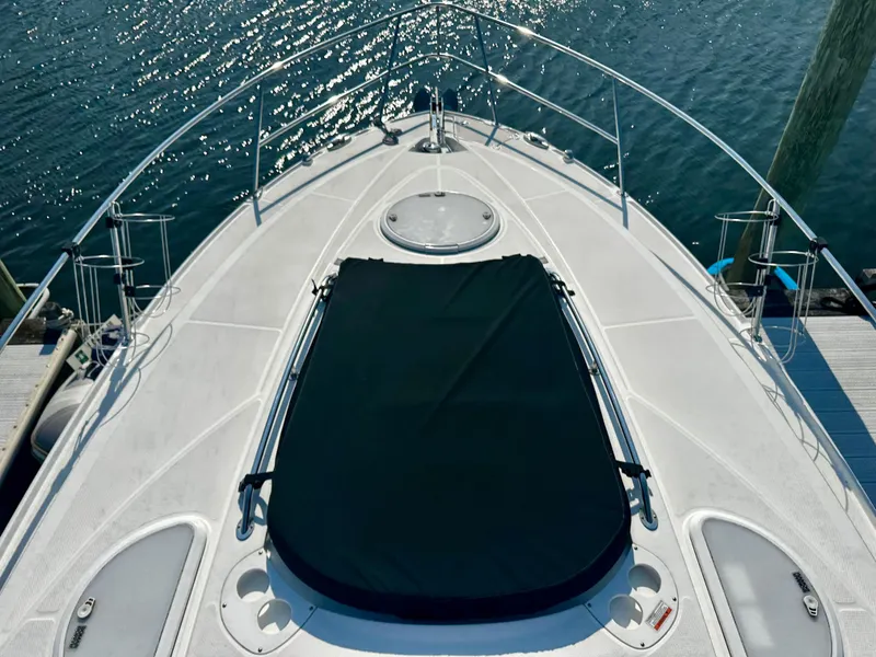 Slide: The Image of 2021 Monterey 335 Sport Yacht bow view with sunpad, docked on calm water. - 6