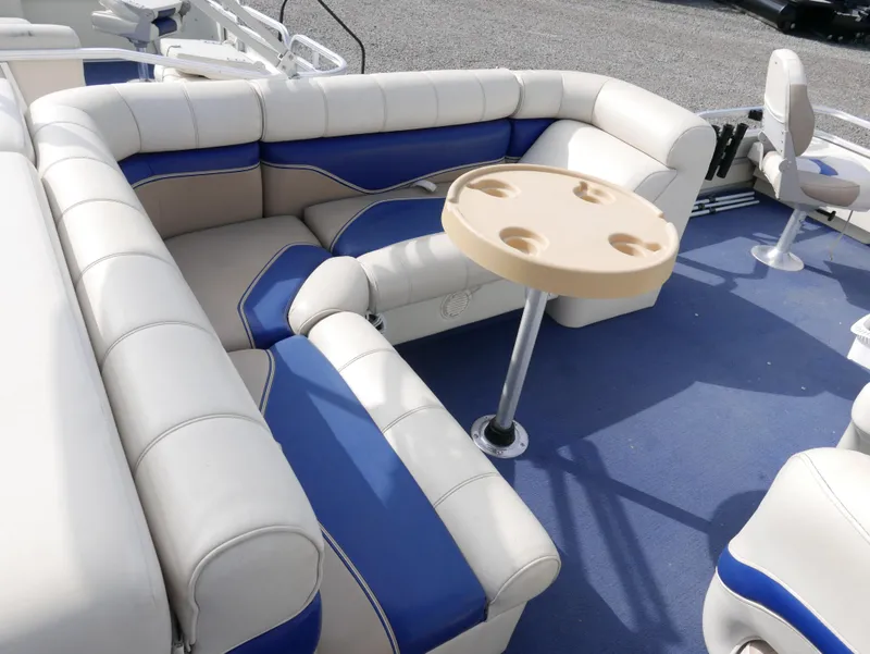 Slide: The Image of 2006 Sweetwater SW2222DF boat interior with blue and white seating and cup holder table. - 10