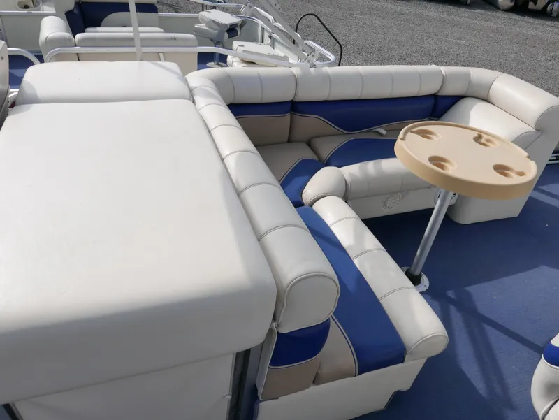 Slide: The Image of 2006 Sweetwater SW2222DF boat with white and blue cushioned seating and a round table. - 11