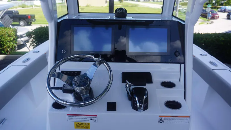 Slide: The Image of 2025 Sportsman 267 Masters boat dashboard with dual screens and steering wheel. - 22
