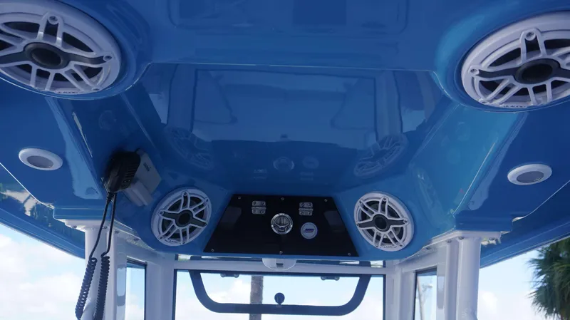 Slide: The Image of 2025 Sportsman 267 Masters boat interior with blue ceiling and integrated speakers. - 23