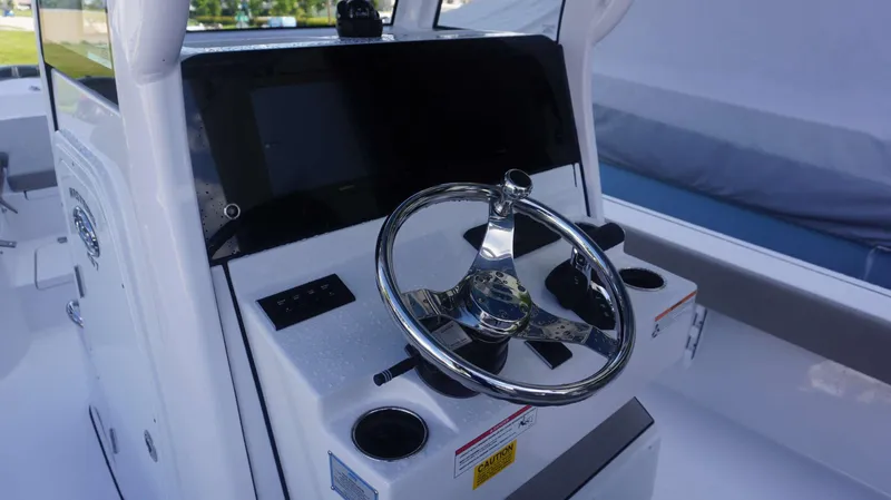 Slide: The Image of 2025 Sportsman 267 Masters boat helm with steering wheel and control panel. - 24