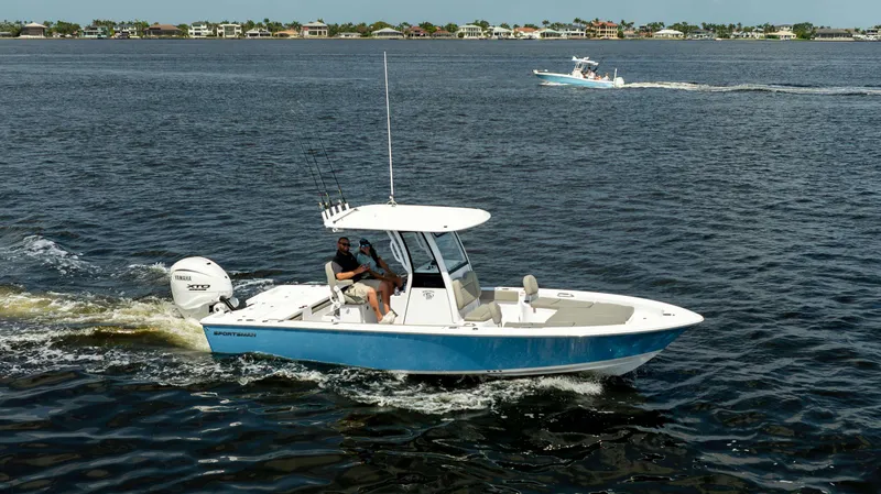 Slide: The Image of 2025 Sportsman 267 Masters boat cruising on open water, with coastal homes in the background. - 4