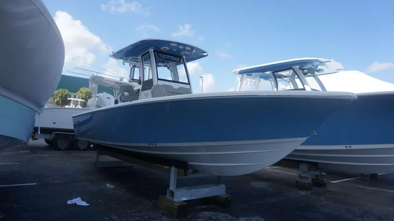 Slide: The Image of 2025 Sportsman 267 Masters boat in blue, displayed outdoors on a stand. - 6