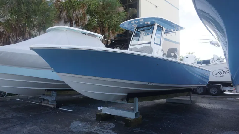 Slide: The Image of 2025 Sportsman 267 Masters boat in blue, displayed outdoors on a stand. - 7