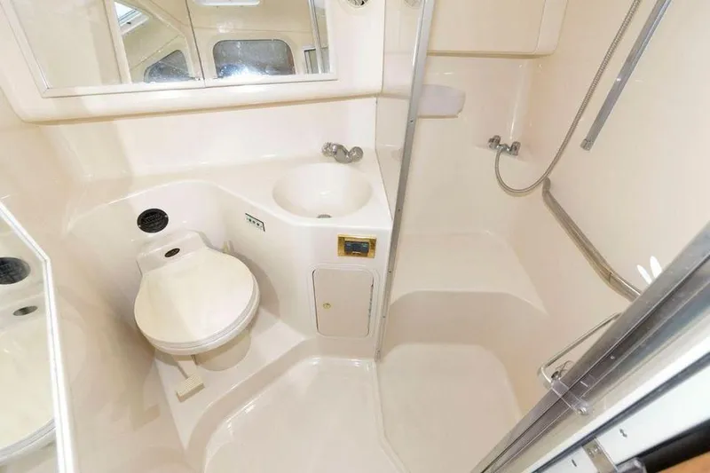 Slide: The Image of 1998 Sea Ray 370 Sundancer bathroom with toilet, sink, and shower. - 10