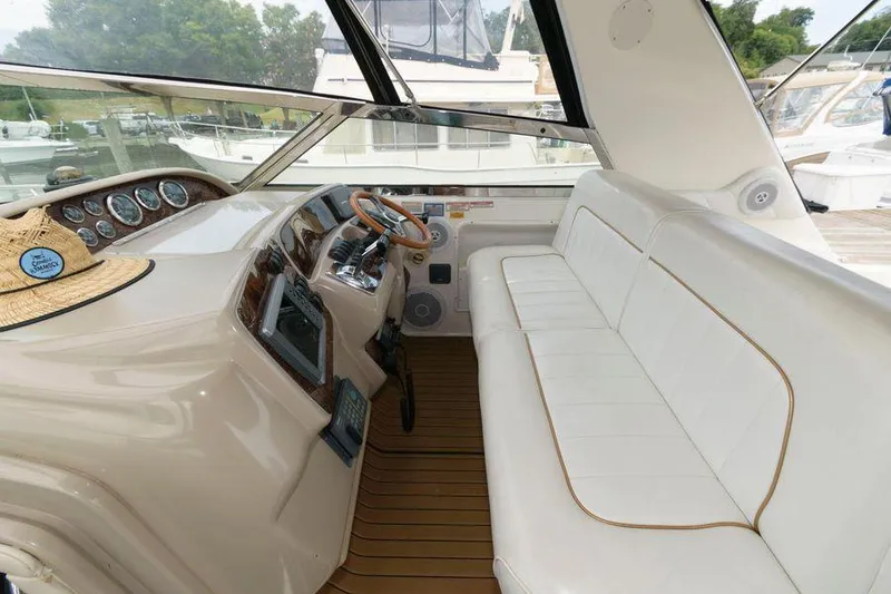 Slide: The Image of 1998 Sea Ray 370 Sundancer cockpit with white seating and wooden accents. - 14