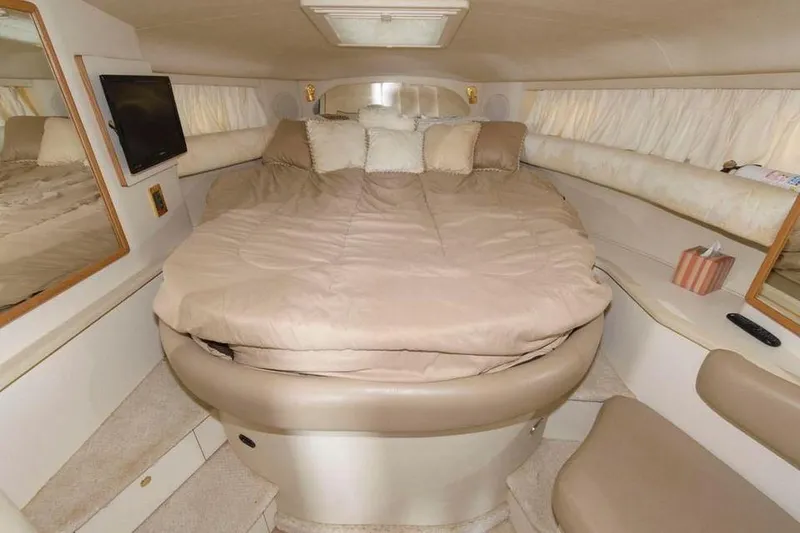 Slide: The Image of 1998 Sea Ray 370 Sundancer cabin with cozy bed and TV. - 8