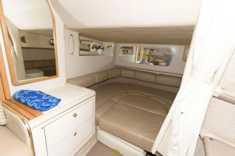 Slide: The Image of 1998 Sea Ray 370 Sundancer cabin with beige leather seating and storage drawers. - 9