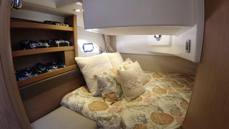Slide: The Image of Cozy bedroom in a 2016 Beneteau GT35 yacht with patterned bedding and wooden shelves. - 29