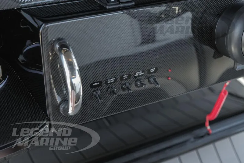 Slide: The Image of Carbon fiber dashboard of 2024 Nor-Tech 340 Sport boat with control switches. - 16