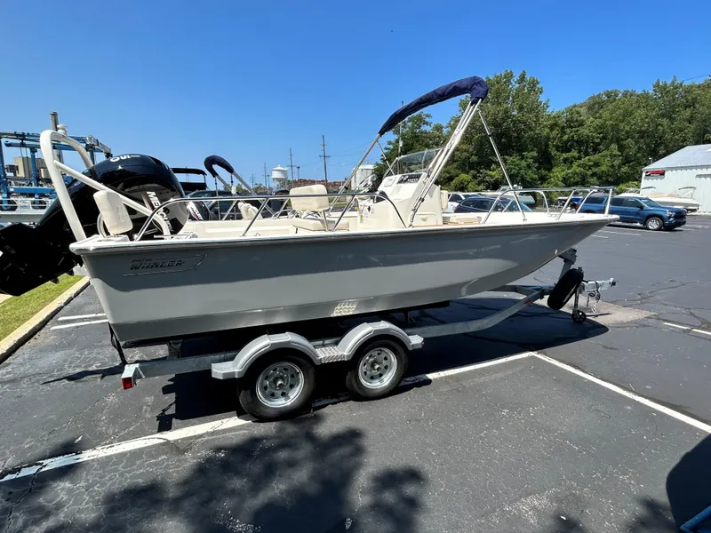 The Image of 2025 Boston Whaler 190 Montauk boat on a trailer in a parking lot. - 0