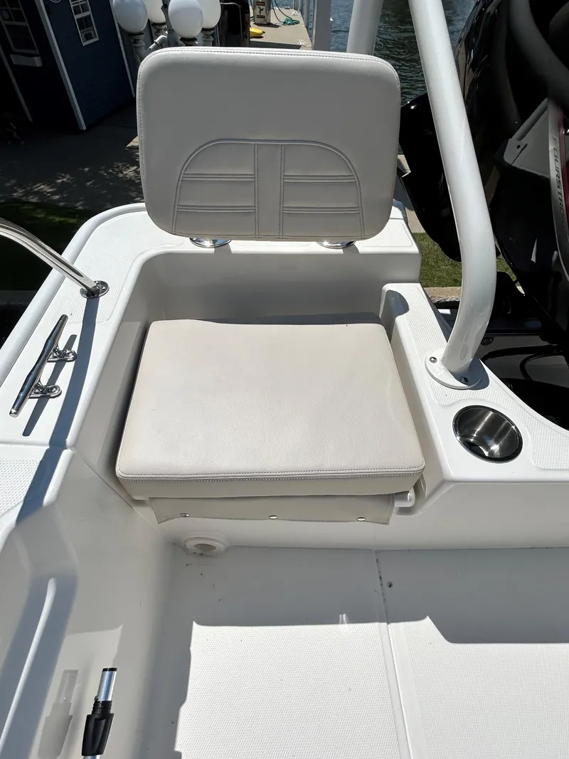 Slide: The Image of 2025 Boston Whaler 190 Montauk boat seat with white cushions and stainless steel cup holder. - 11