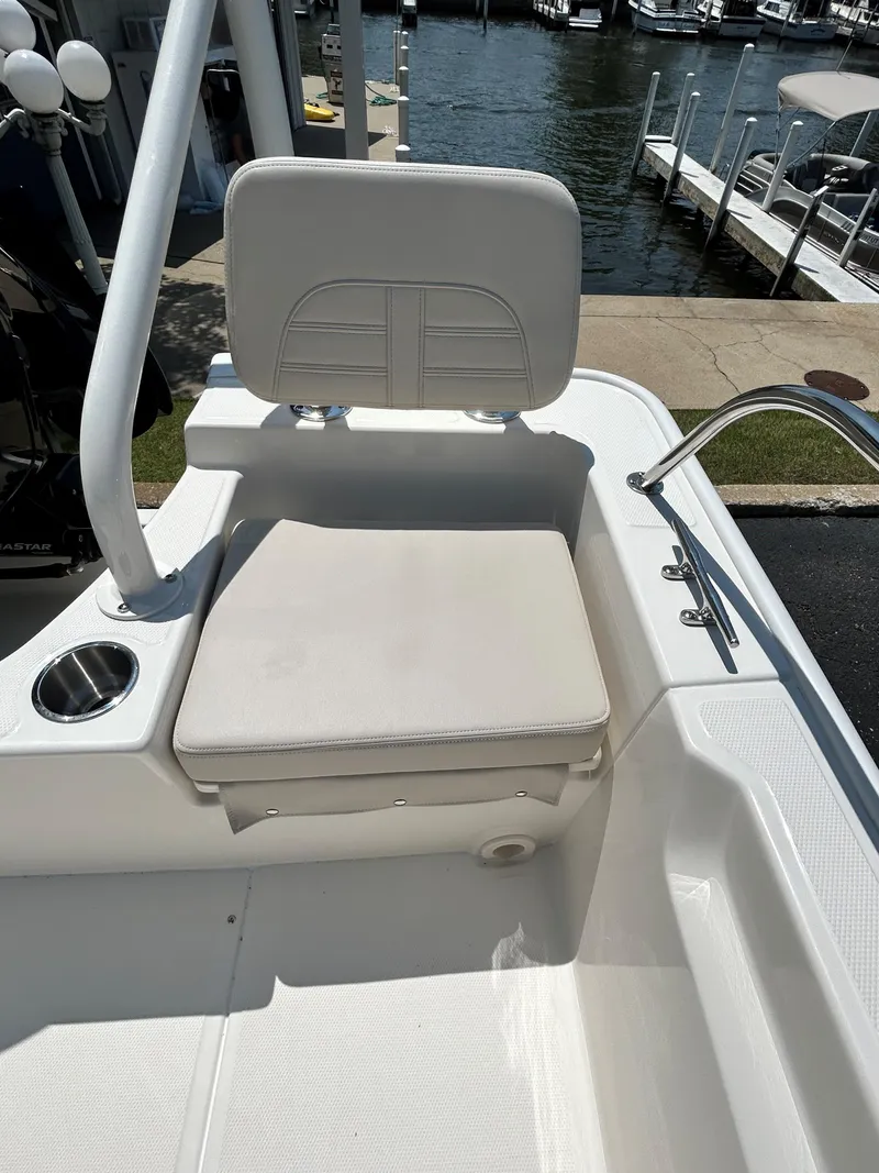 Slide: The Image of 2025 Boston Whaler 190 Montauk boat seat with cup holder, docked by the water. - 12