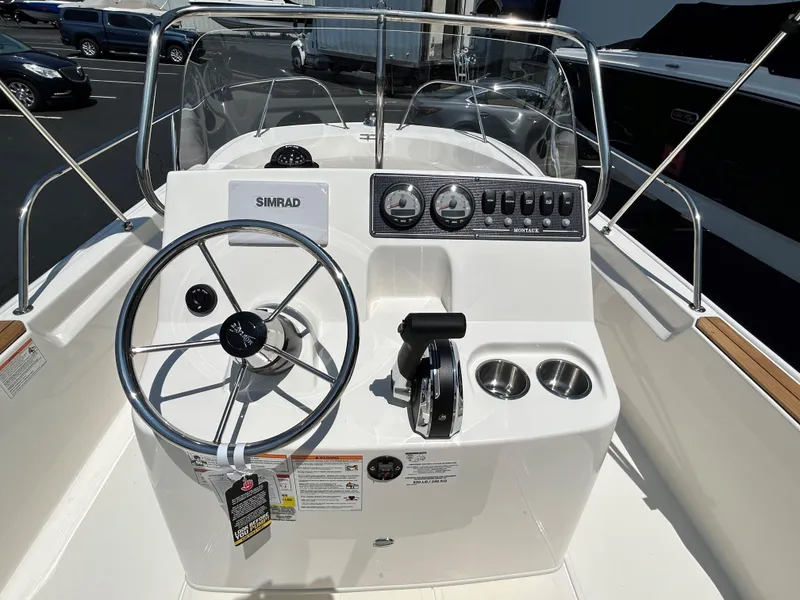 Slide: The Image of 2025 Boston Whaler 190 Montauk boat console with steering wheel and controls. - 3