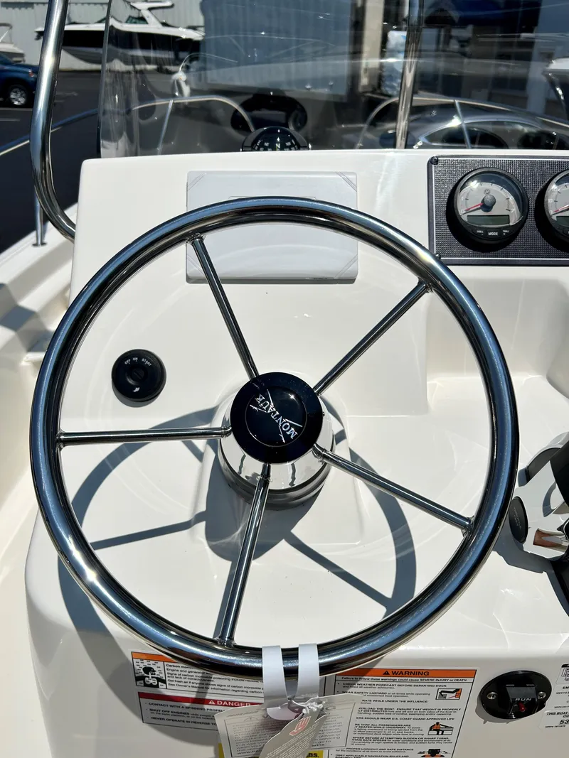 Slide: The Image of 2025 Boston Whaler 190 Montauk steering wheel and dashboard controls. - 4