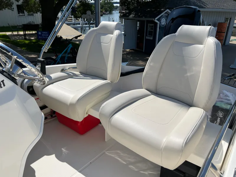 Slide: The Image of 2025 Boston Whaler 130 Super Sport boat interior with white cushioned seats. - 4
