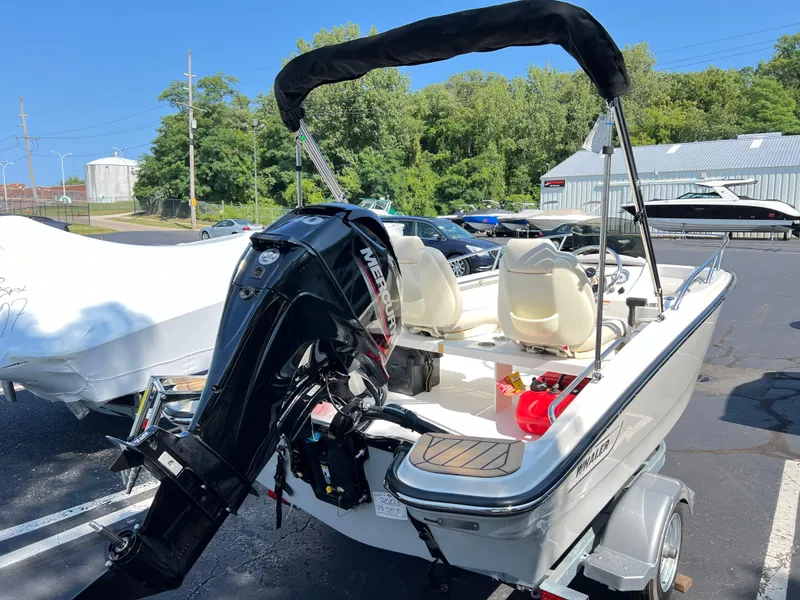 Slide: The Image of 2025 Boston Whaler 130 Super Sport boat with Mercury outboard motor in parking lot. - 9