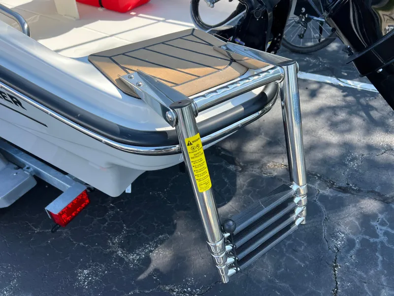 Slide: The Image of 2027 Boston Whaler 130 Super Sport interior with white seating and steering console. - 8