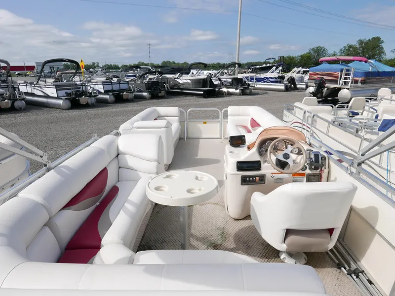 Slide: The Image of 2006 Odyssey Pontoons 525CTTI/O with white and red seating, docked among other boats. - 11