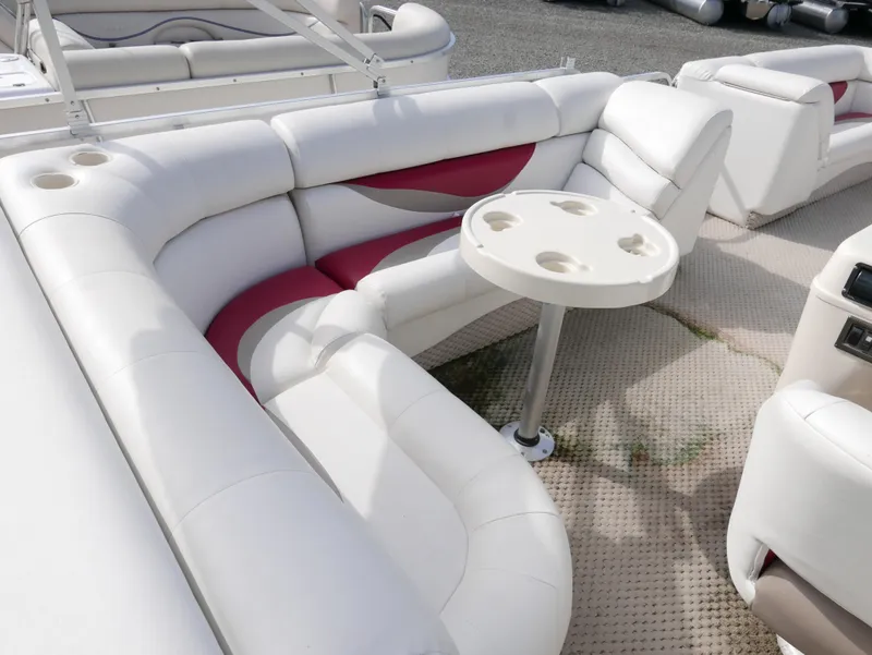 Slide: The Image of 2006 Odyssey Pontoons 525CTTI/O interior with white and red seating and a round table. - 9